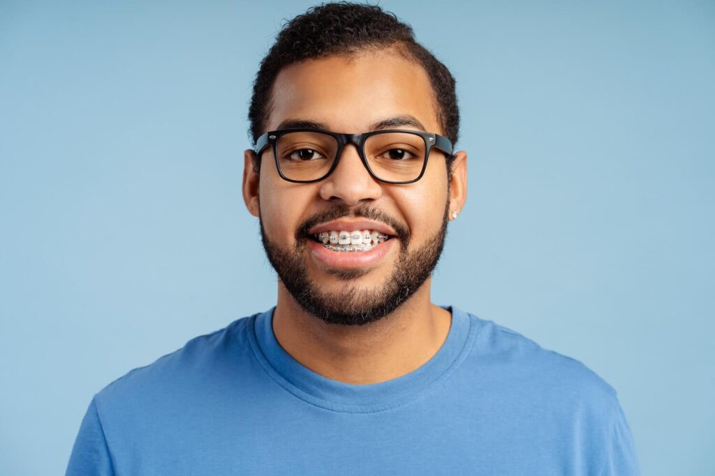 Adult wearing eyeglasses smiling with braces
