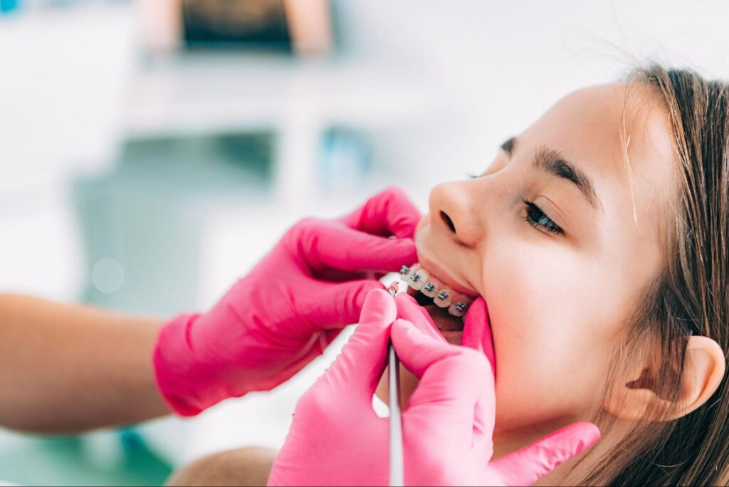 Young girl receiving a dental adjustment for her braces